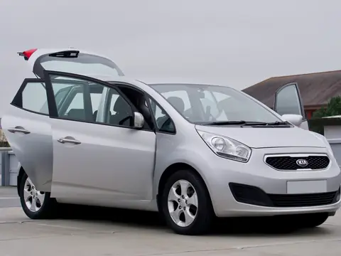 A silver minivan parked with all its doors open